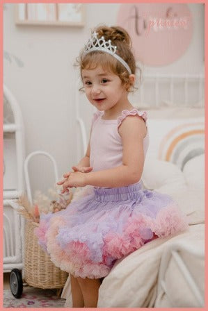 Girl wearing lilac and pastel rainbow petticoat tutu and silver tiara